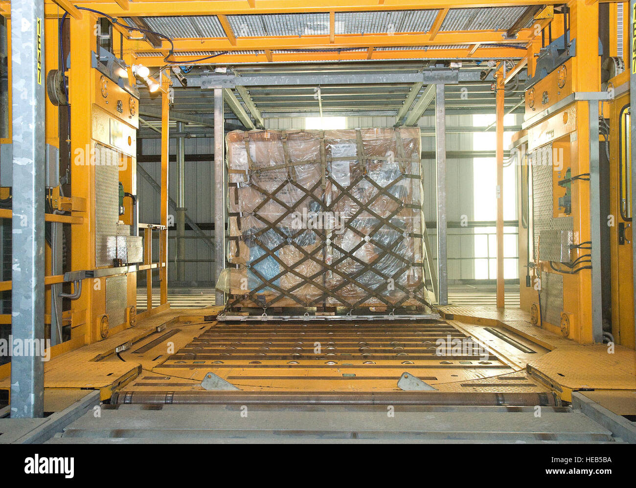 Eine Palette von Cargo rollt auf eine der beiden erhebend Transferfahrzeuge 4. Mai 2015, bei der 436th Antenne Port Squadron auf der Dover Air Force Base, Del. Paletten sind vorübergehend untergebracht in einem mehrstufigen Palette Raster terminal wo ein Computersystem erinnert sich genau, wo die spezifische Palette gespeichert ist. Wenn die Palette auf ein Flugzeug verladen werden kann, ruft der ETV die Palette in der gewünschten Reihenfolge auf einem Cargo Lader, und dann in ein Flugzeug geladen werden. Roland Balik) Stockfoto