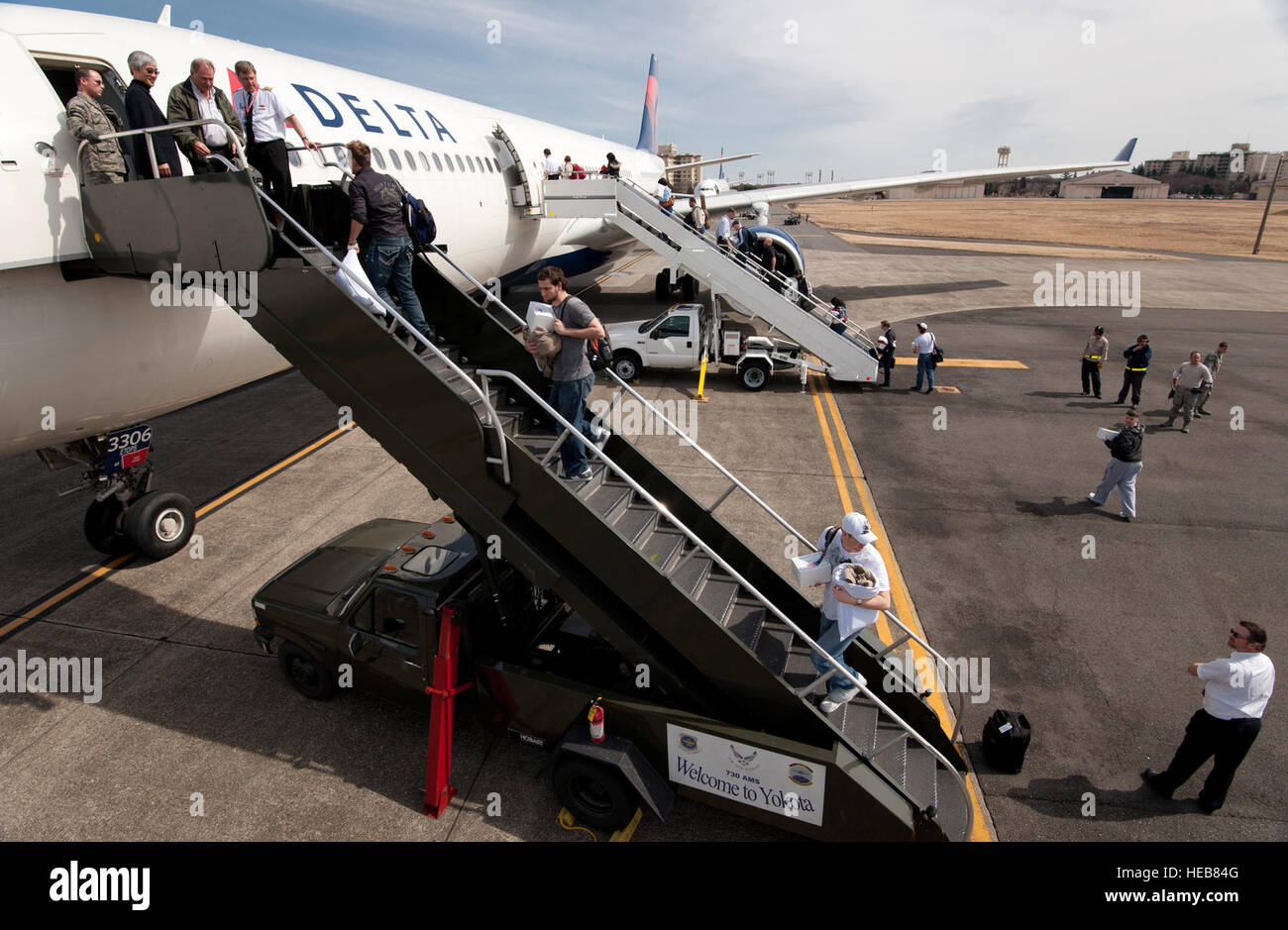 Passagiere an Bord zwei Delta Airlines Flugzeuge auf der Yokota Air Base, Japan; 12. März 2011. Die Flugzeuge wurden an Yokota AB vom Narita International Airport umgeleitet, nachdem ein Erdbeben der Stärke 8,9 vor der östlichen Küste von Japan geschlagen.  Staff Sgt Samuel Morse)(Released) Stockfoto