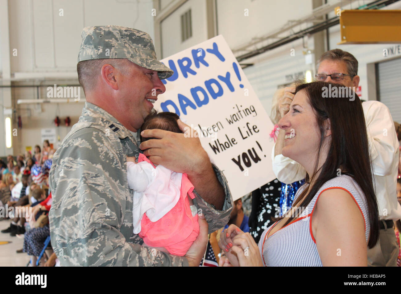 Seine Tochter, Quinn, zum ersten Mal treffen, kehrt Kapitän Kevin McKay aus einem sechsmonatigen Einsatz mit der 117. Air Control Squadron. Seine Frau, Ariel, gebar 21. März 2014. Quinns Plakat sagt schon alles, "Papa beeilen, ich warte schon mein ganze Leben, Sie zu treffen!" Die 117ACS GA ANG kehrte Hunter Army Airfield nach Kontrolle der Himmel über Südwestasien seit November letzten Jahres. Stockfoto