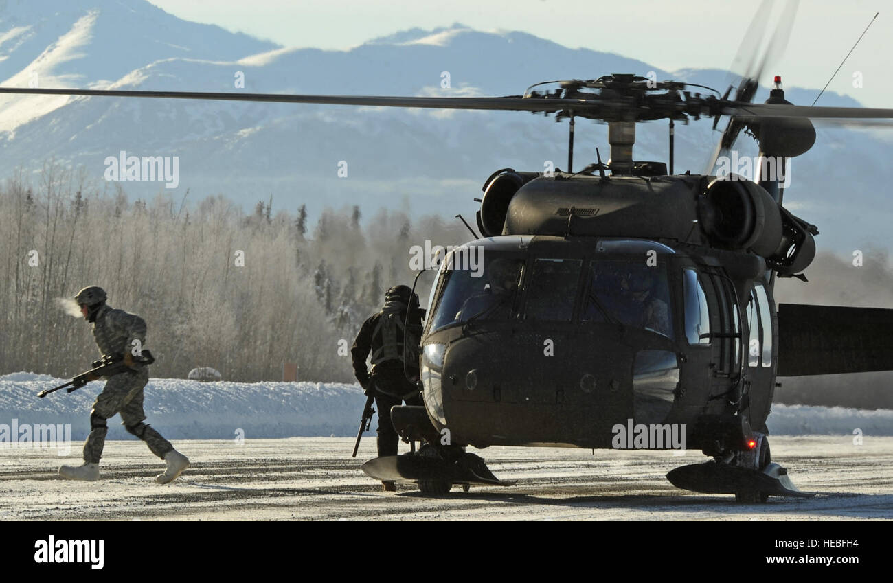 Eines US-Soldaten des 1. Bataillons, 501st Fallschirm-Infanterie-Regiment zugewiesen läuft 4. Infantry Brigade Combat Team, 25. Infanterie-Division, U.S. Army Alaska Weg von einem UH-60 Black Hawk-Hubschrauber mit einem M107.50 Kaliber Langstrecken Scharfschützengewehr nach Eingriff Ziele aus einer Hubarbeitsbühne im Hubschrauber über der Malamute-Drop-Zone am gemeinsamen Basis Elmendorf-Richardson, Alaska, März 7 , 2014. (US Air Force Foto von Justin Connaher/freigegeben) Stockfoto