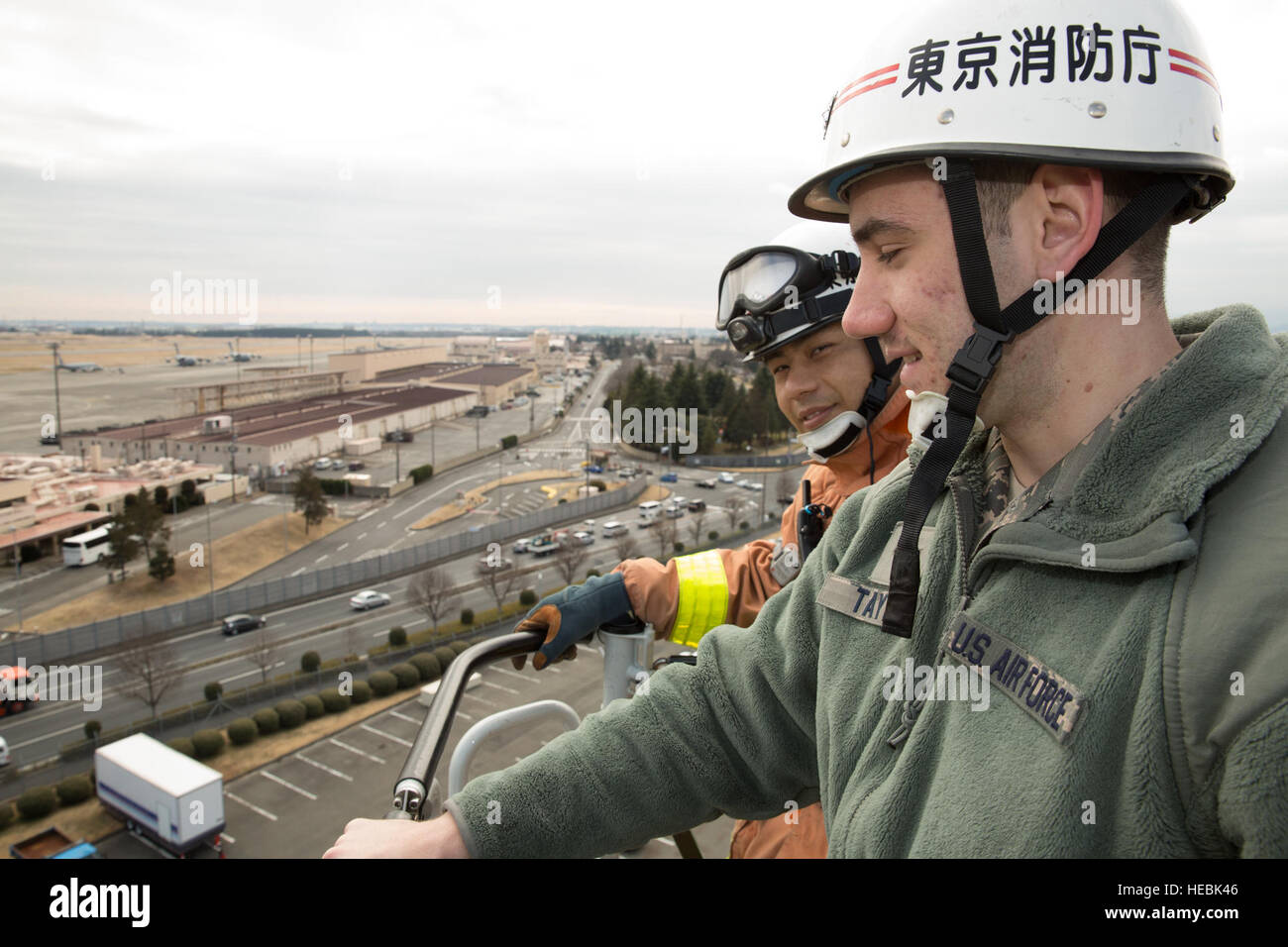 Feuerwehrleute der Luftwaffe und der Tokioter Feuerwehr demonstrieren auf einem Sicherheitsfestival auf der Yokota Air Base, Japan, den Einsatz von Leiterwagen und informieren die Bewohner über Notfallmaßnahmen und Sicherheitsmaßnahmen. Stockfoto