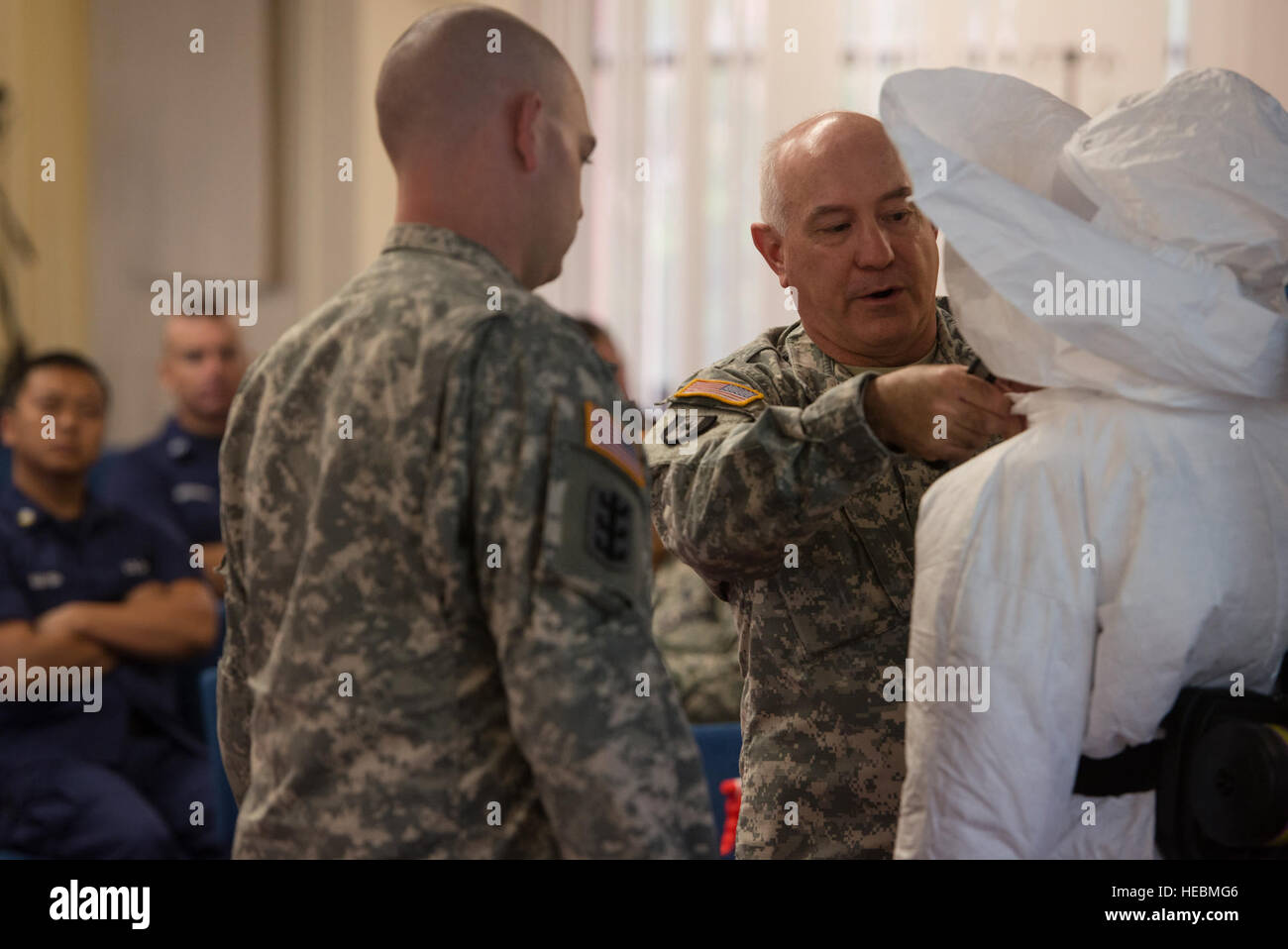 Zeigen Sie US Army Lt. Col. Neal Woollen (Mitte), Direktor der USA Armee Medical Research Institute of Infectious Diseases (USAMRIID) des Bio-Sicherheit, und US Armee Sgt. Daniel Vita (links), USAMRIID combat Medic, den Kursteilnehmern wie persönlichen Schutzausrüstung mit Hilfe der US-Armee Pfc. Kaiya Capuchino, USAMRIID combat Medic, während Gefahrstoff Ausbildung 30. Oktober 2014, bei Tripler Army Medical Center Don , Hawaii. Mitglieder der USAMRIID führte die Klasse, um sicherzustellen, dass Service-Mitglieder und Zivilisten sind besser vorbereitet zu reagieren und wehren sich gegen Infektionskrankheiten bei Stockfoto