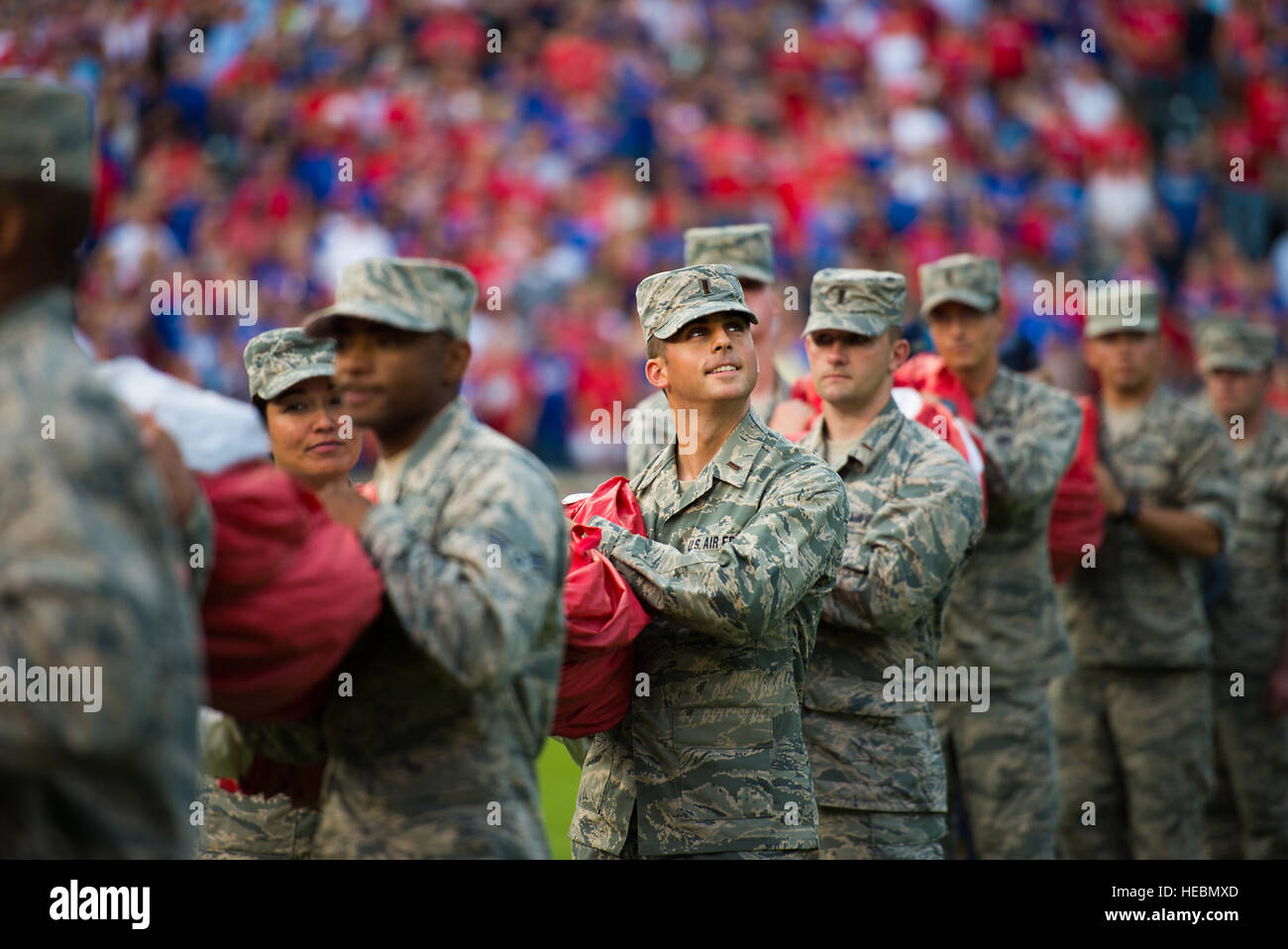 US Air Force 2nd Lt. Tyler Almquist, Student an der Sheppard Air Force Base, Texas, hilft eine riesige US-Flagge für eine Eintragung Zeremonie bei der Eröffnung des Rangers Spiel in Arlington, Texas, 4. Juli 2015 halten. Mehr als 60 Flieger von Sheppard freiwillig mit der 344th Recruiting Geschwader zu helfen, die Flagge für rund 150 neue Luftwaffe Enlistees entfalten, die geschworen-während des Spiels. (US Air Force Foto von Senior Airman Kyle Gese/freigegeben) Stockfoto