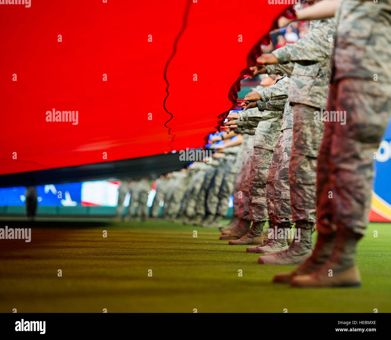 US Air Force Piloten von Sheppard Air Force Base, Texas, helfen, einen riesigen US-Flagge für eine Eintragung Zeremonie bei der Eröffnung des Rangers Spiel in Arlington, Texas, 4. Juli 2015 halten. Mehr als 60 Flieger von Sheppard freiwillig mit der 344th Recruiting Geschwader zu helfen, die Flagge für rund 150 neue Luftwaffe Enlistees entfalten, die geschworen-während des Spiels. (US Air Force Foto von Senior Airman Kyle Gese/freigegeben) Stockfoto
