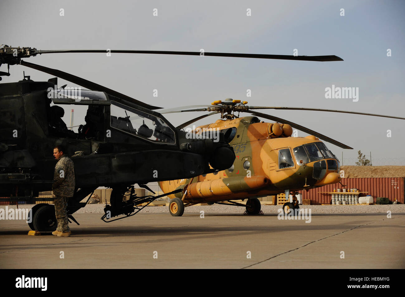 Ein US-Armee AH-64 Apache und einem afghanischen nationalen Armee Mi-17 fungieren als statische Displays vor einem Banddurchtrennungszeremonie die volle Länge der Start-und Landebahn auf Shindand Air Base, Afghanistan, 20. Dezember 2010 offiziell eröffnet.  Die Landebahn ist nun in der Lage, Flugzeuge so groß wie die c-17 Globemaster III.  (US Air Force Photo/Staff Sgt Eric Harris) (FREIGEGEBEN) Stockfoto