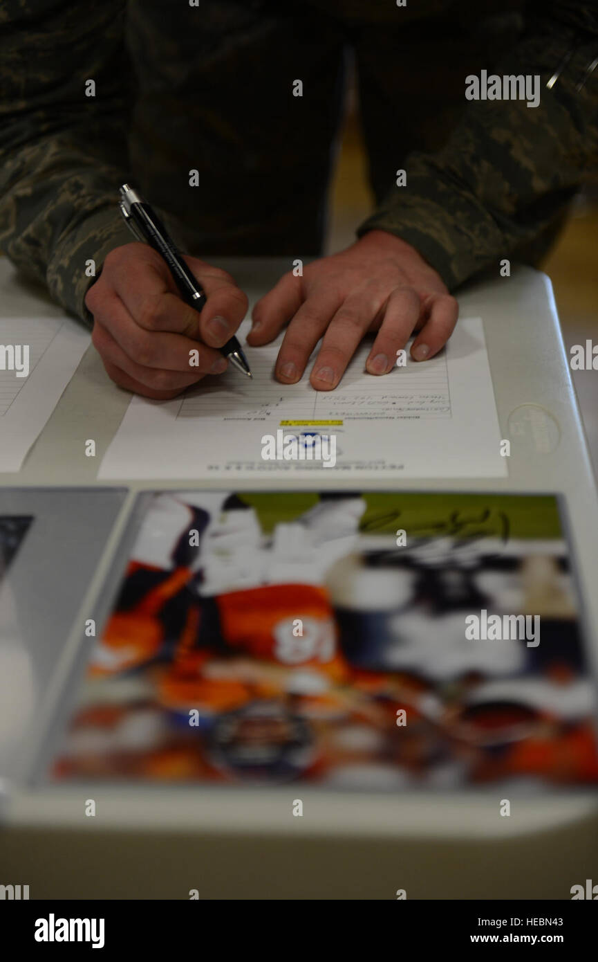 SPANGDAHLEM AIR BASE, Deutschland – US Air Force Airman 1st Class Steven Leonard, 52. Komponente Wartung Geschwader Brennstoffe Systeme Techniker aus Lancaster, Kalifornien, ein Angebot für ein signiertes Foto während einer stillen Auktion im Brick House 31. Mai 2013 setzt.  Die Gelder gehen in Richtung Betrieb warmes Herz, ein Programm entwickelt, um Versatz die Bedürfnisse der Flieger mit Blick auf Notstands-finanzielle Nöte. (Foto: U.S. Air Force Flieger 1. Klasse Gustavo Castillo/freigegeben) Stockfoto