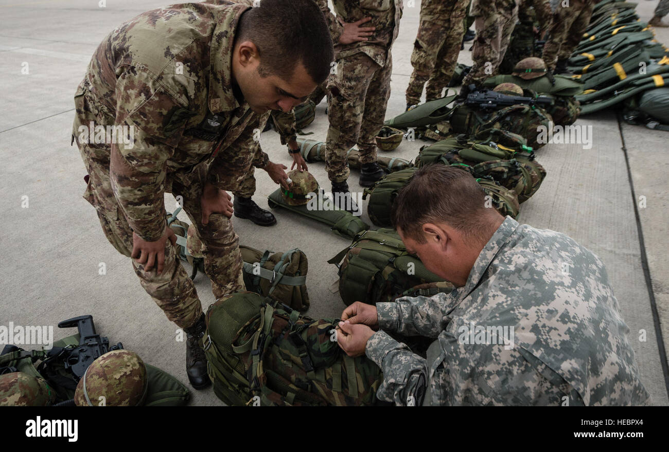 US Army Staff Sgt Tod Barclay, 1-91st Cavalry Camanche Truppe, hilft italienischen Caporalemaggiore Domenico Dellipaoli, 2. Eskadron, 2. Zug, 186. Regiment Folgore mit seinem Fallschirm während eines Ausbildung Aspekt im Rahmen der Übung Steadfast Javelin II auf Ramstien Air Base, Deutschland, 3. September 2014 rigging. Der Übung Features die eine Reihe von dynamischen Events der multinationalen Kräfte in Luftlandeoperationen, konventionelle Kriegsführung Szenarien als auch Stabilität und defensiven Operationen und Unterstützung der zivilen Behörden Operationen herausfordern. (U.S. Air Force Photo/Flieger 1. Klasse Jordan Caste Stockfoto