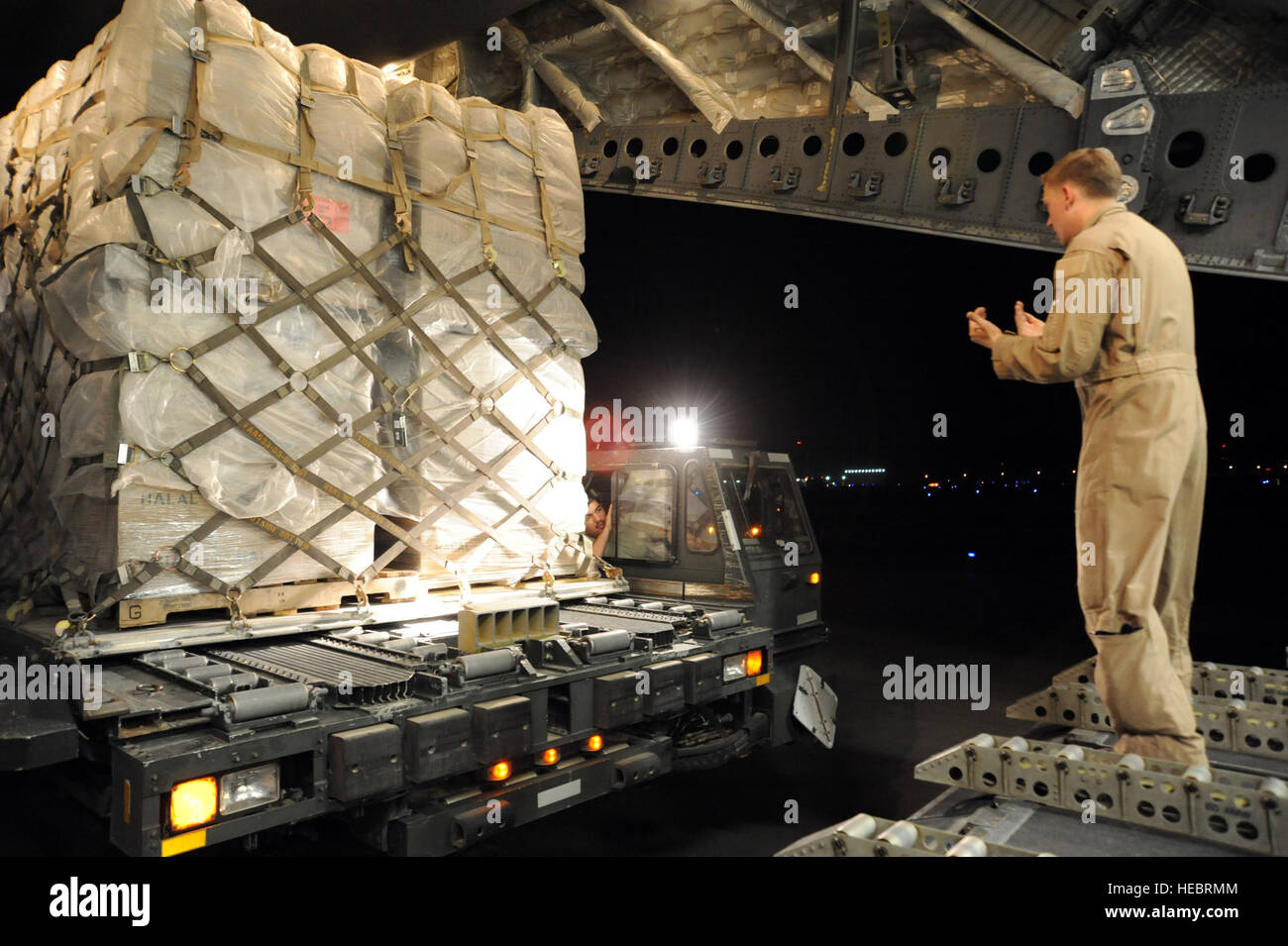 US Air Force Senior Airman Brandon Cain, Recht, ein Loadmaster bereitgestellt von Joint Base McGuire-Dix-Lakehurst, New Jersey, führt Flieger 1. Klasse Armando Tovar, mit 386th Expeditionary Logistik Bereitschaft Geschwader bei ihrer Vorbereitung auf Paletten mit humanitären Hilfsgütern in einer c-17 Globemaster III Flugzeug an einem unbekannten Ort im Südwesten Asien 4. Juni 2013, laden transportiert werden zur Unterstützung der syrischen Opposition zwingt. Die US-Regierung leistete die Flügelschlagfrequenz Hilfe Oppositionsgruppen im syrischen Bürgerkrieg. (US Air Force Foto von Senior Master Sergeant George Thompson/freigegeben) Stockfoto