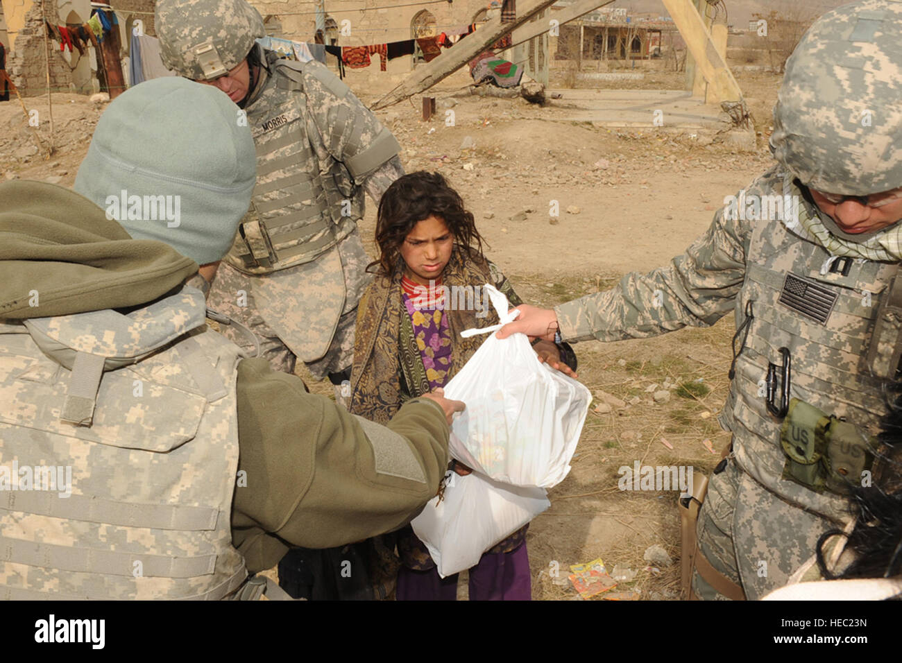 US-Militärangehörige geben ein afghanisches Mädchen einen Beutel mit Spielzeug in einem Flüchtlingslager während einer freiwilligen Community Relations (VCR) Mission in Kabul, Afghanistan, 18. Dezember 2009. Das VCR-Programm, durch das Camp Eggers Kapläne, erleichtert nutzt militärische und zivile freiwillige Güter gestiftet von individuellen und gemeinnützige Organisationen in den USA und im Ausland zu verteilen. VCR freiwillige Interaktion mit lokalen Staatsangehörigen an verschiedenen Orten in Kabul, einschließlich Schulen, Waisenhäuser, medizinische Zentren und Lager für Vertriebene, Verbesserung der Lebensqualität aller Beteiligten. (US Air Force Foto S Stockfoto