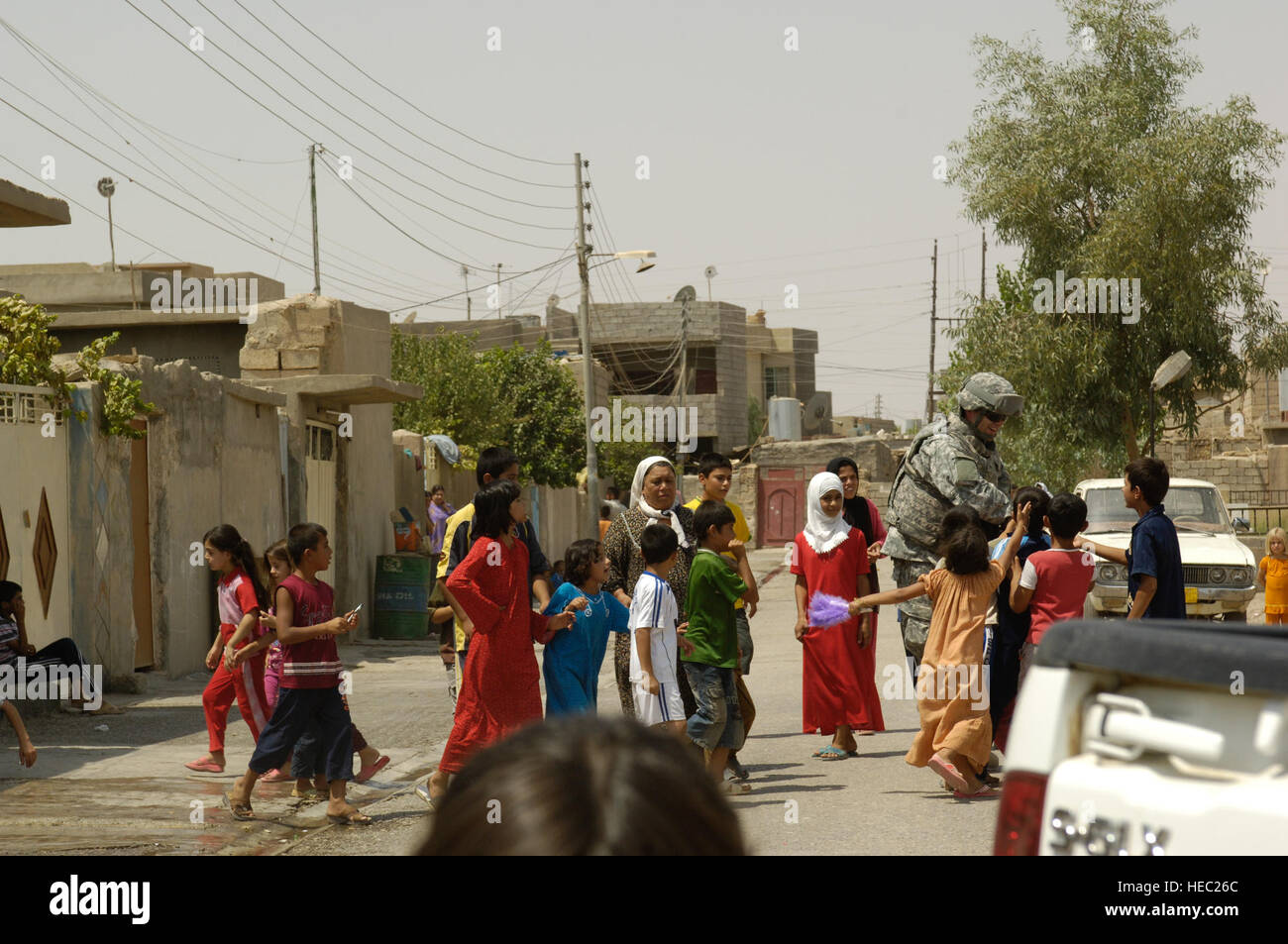 Ein US-Soldat, Alpha-Batterie, 3. Bataillon, 6. Feldartillerie, 10th Mountain Division, Fort-Trommel, N.Y., bereitgestellt, Forward Operating Krieger, Kirkuk, Irak, ist während des Besuchs Altun Kapri, 20. August 2008 von Kindern wimmelte. Stockfoto