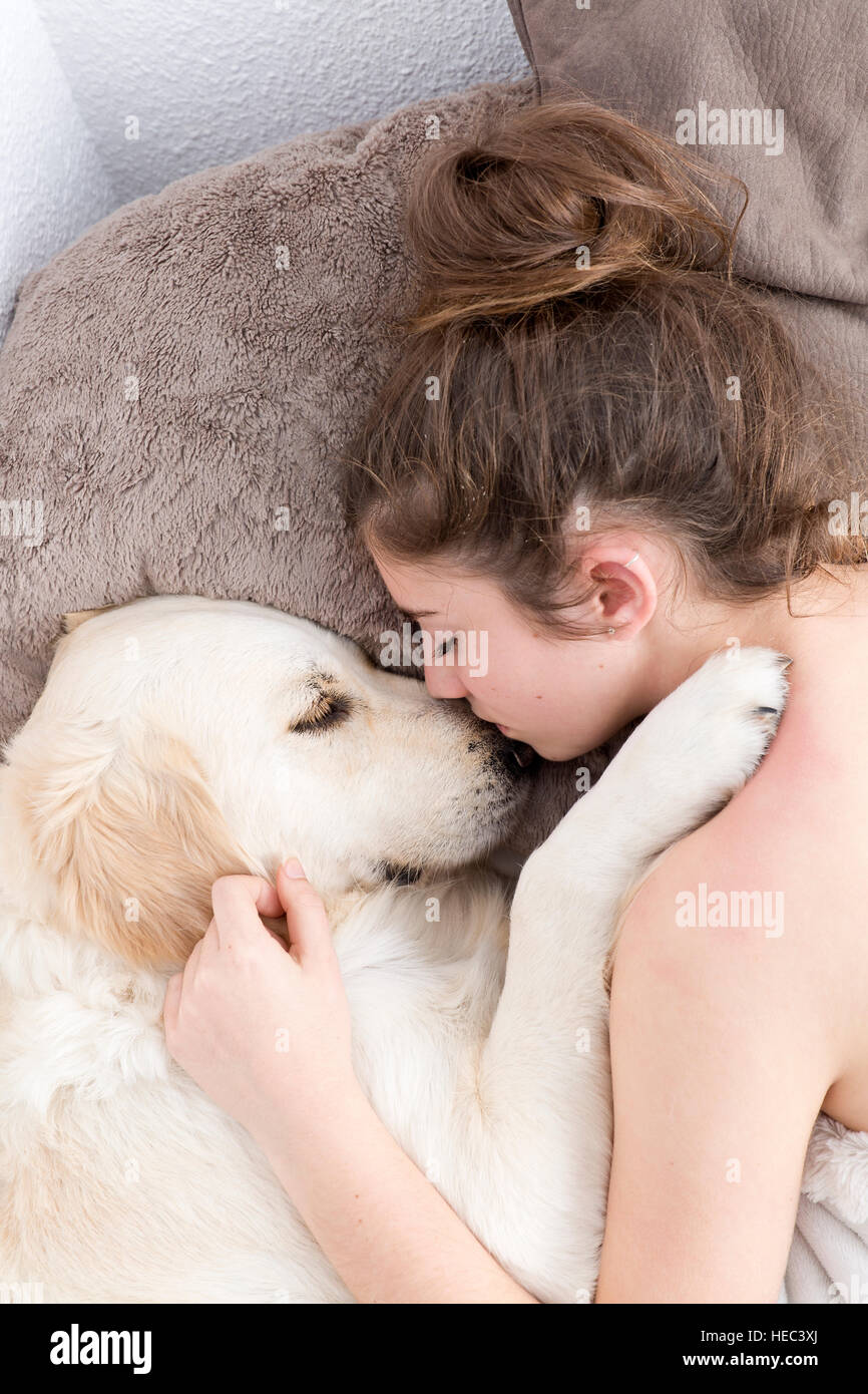 Teenager-Mädchen mit ihrem Hund weiter zu schlafen. Vertikal mit Tupfer Licht aus Flachs Studio gedreht. Stockfoto