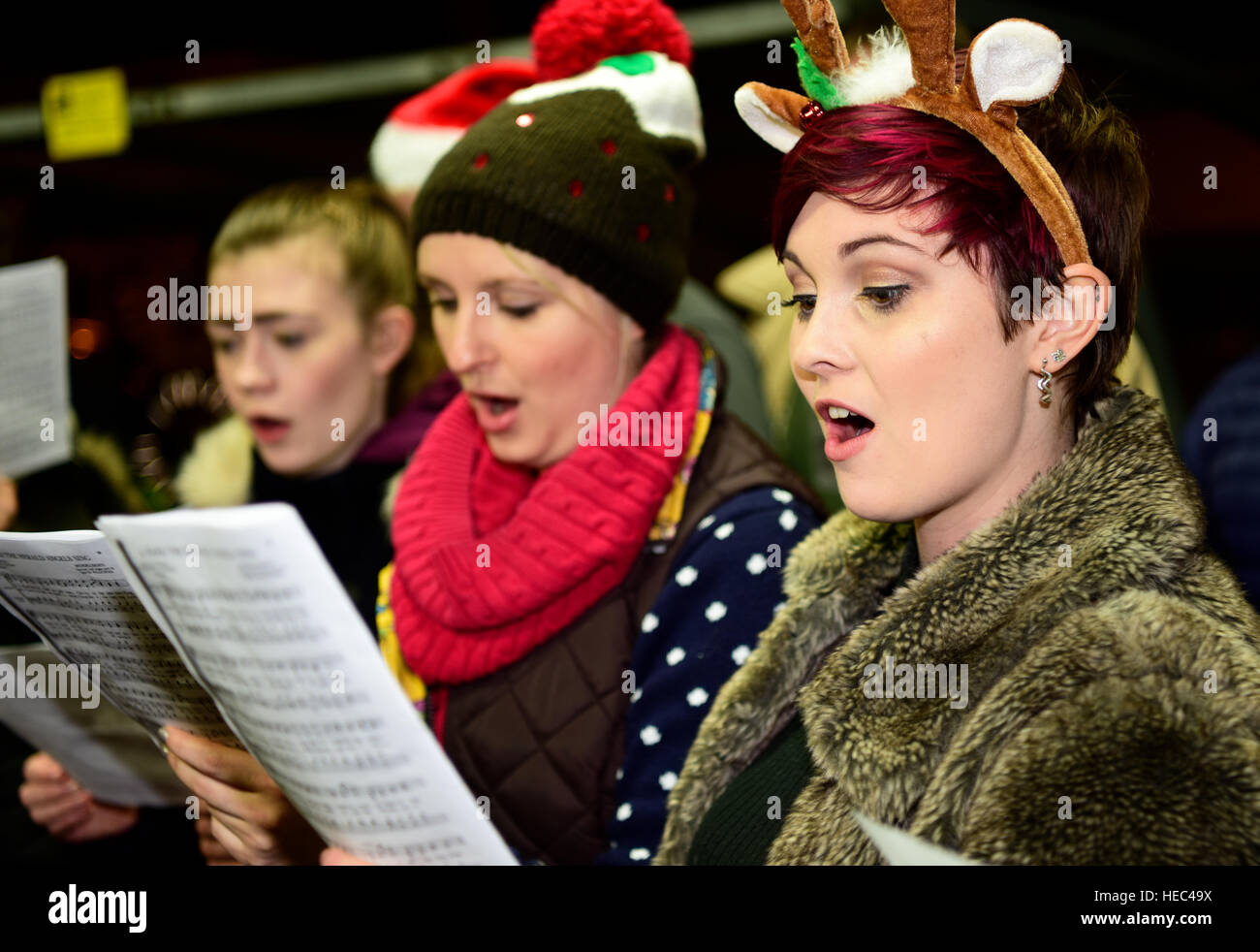 Marie Curie Cancer Charity Freiwilligen singen Weihnachtslieder in einem Zug station Plattform, Farnham, Surrey, UK. Stockfoto