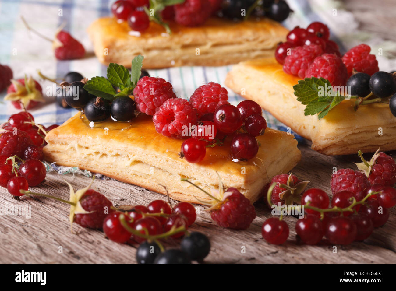 Hausgemachte Kuchen mit Himbeeren, Johannisbeeren, Honig und Minze auf eine Tabelle Nahaufnahme. Stockfoto