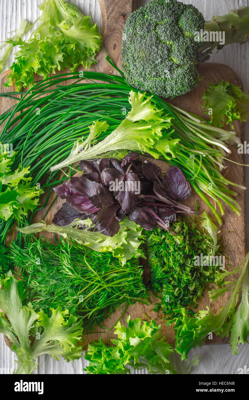 Brokkoli, Salat, Basilikum, Zwiebel, Dill auf Schneidebrett vertikale Stockfoto