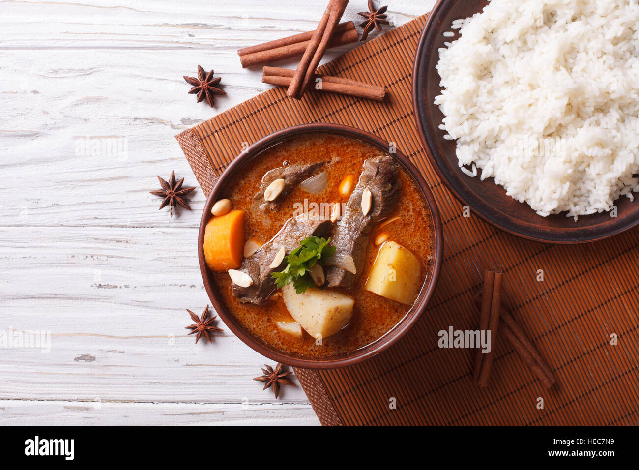 Heißen traditionelle Thai Rindfleisch Massaman Curry mit Erdnüssen und Reis-Beilage. horizontale Ansicht von oben Stockfoto