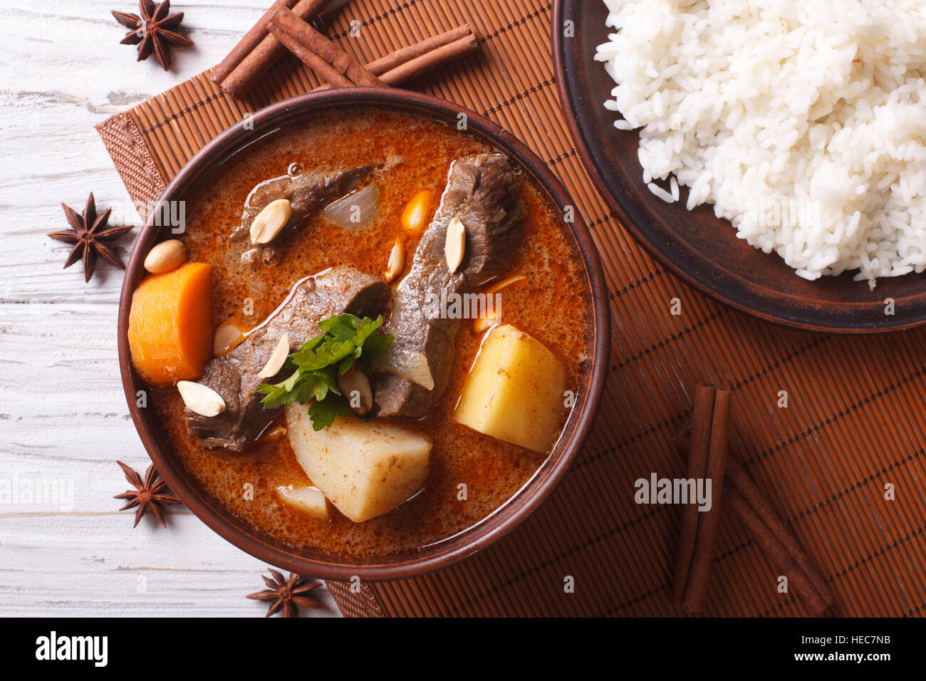 Heißen traditionelle Thai Rindfleisch Massaman Curry mit Erdnüssen und Reis Beilage hautnah. horizontale Ansicht von oben Stockfoto