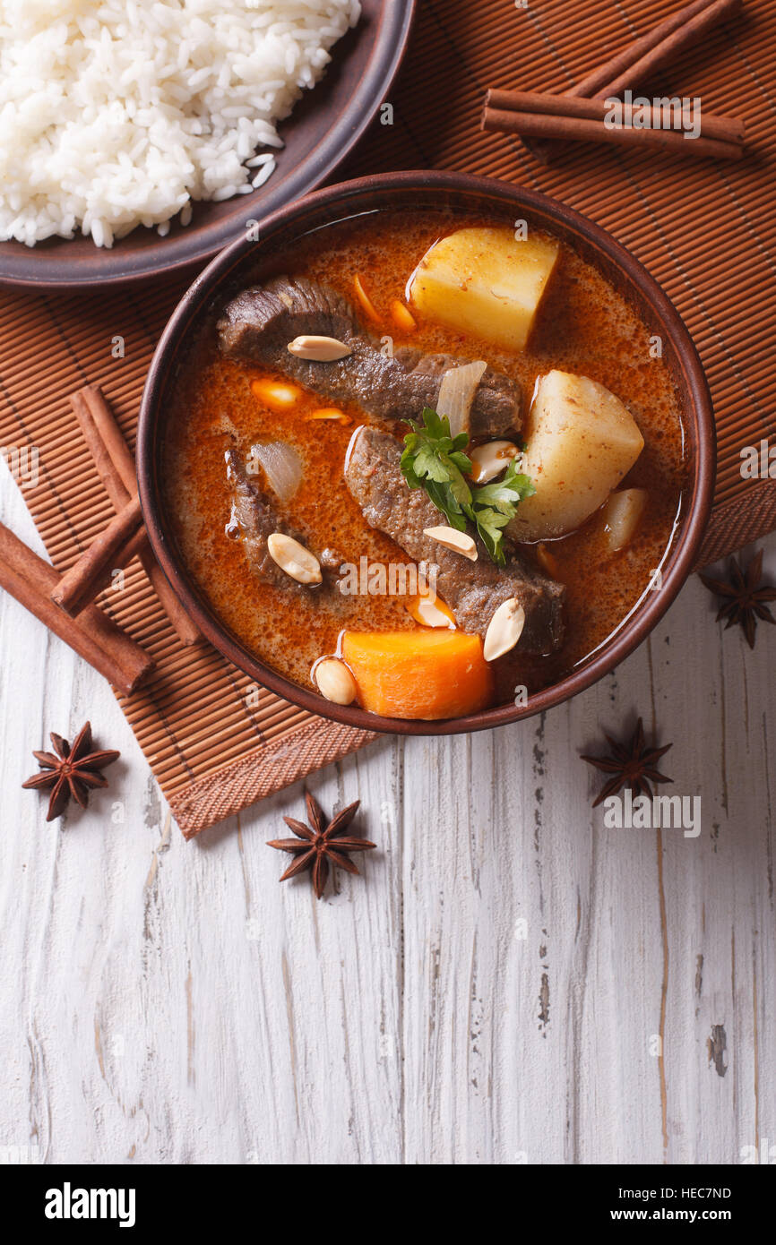Heißen traditionelle Thai Rindfleisch Massaman Curry mit Erdnüssen und Reis-Beilage. vertikale Ansicht von oben Stockfoto