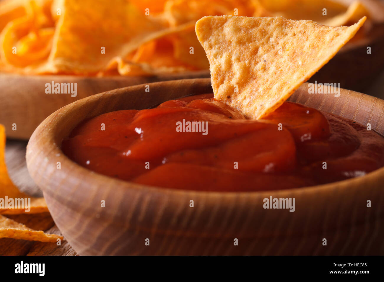 Tomatensauce in eine hölzerne Schüssel und Mais-Chips Nachos Makro. horizontale Stockfoto