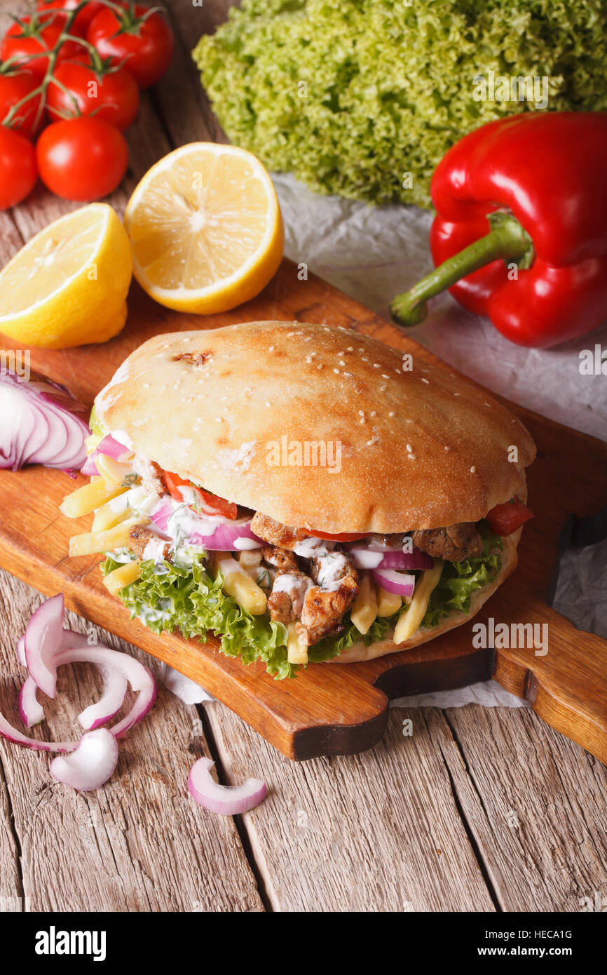 Döner Kebap mit Fleisch und Gemüse in Pita Brot Nahaufnahme auf dem Tisch. vertikale Stockfoto