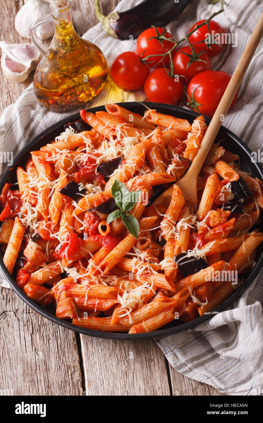 Italienische Küche: Penne mit Auberginen und Tomaten Nahaufnahme auf den Tisch und Zutaten. Vertikal Stockfoto