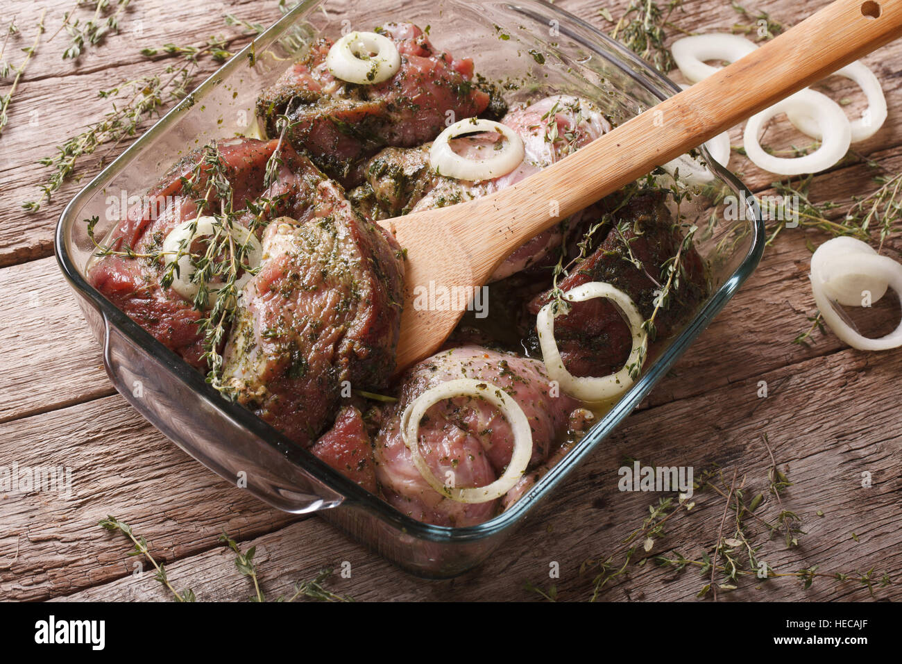 Rohes Fleisch in einer grünen Marinade mit Kräutern und Zwiebeln in einer Schüssel hautnah. horizontale Stockfoto