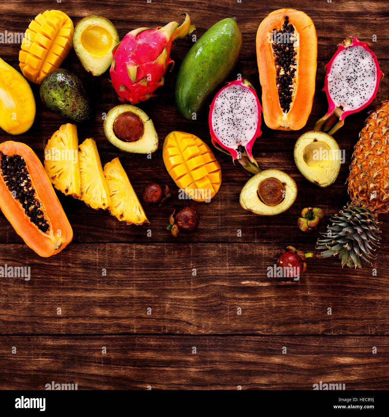 Frische tropische Früchte auf dunklem Holz, Ansicht von oben Stockfoto