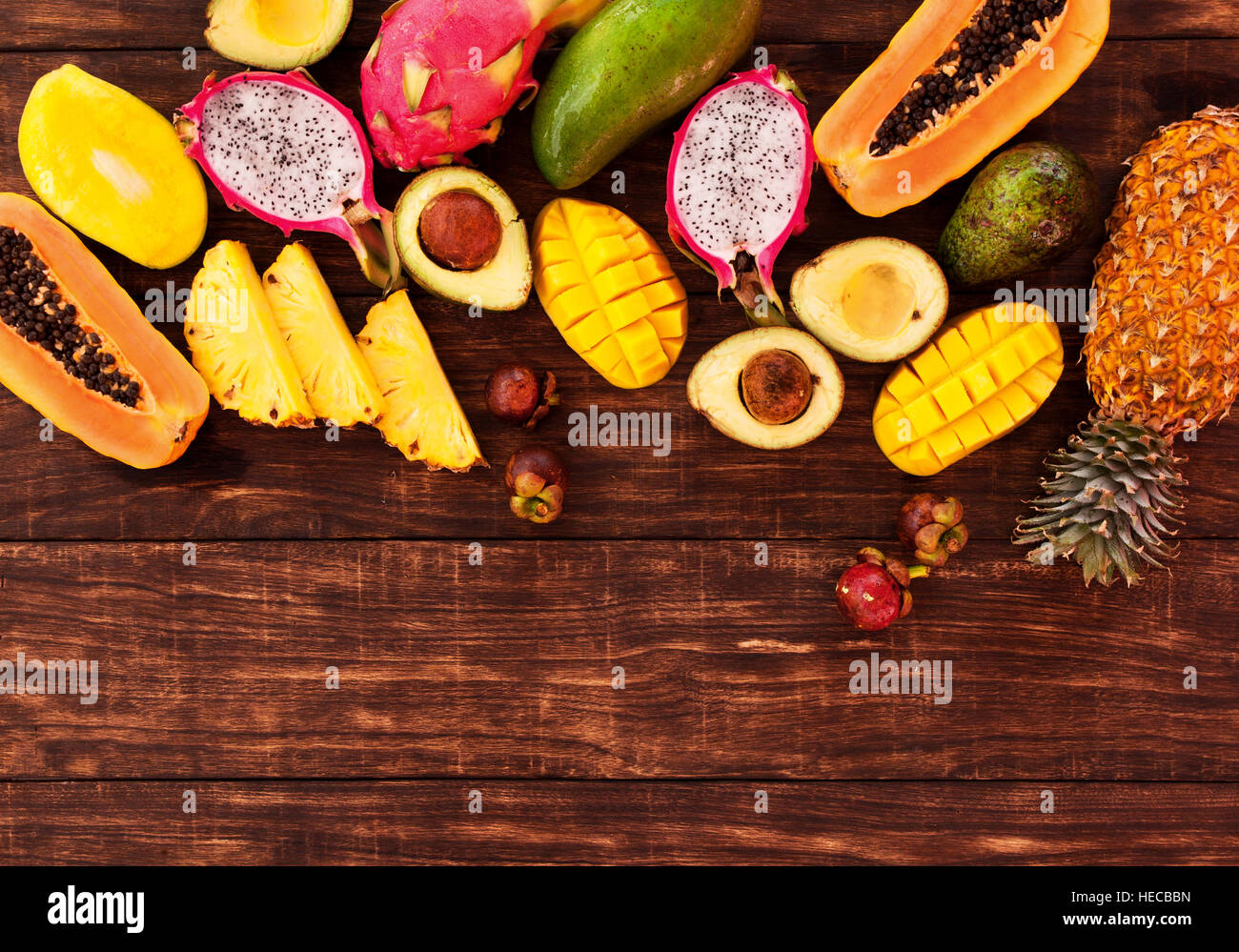 Frische tropische Früchte auf dunklem Holz, Ansicht von oben Stockfoto