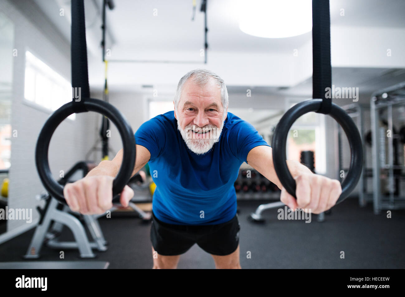 Senior woman in Sportkleidung in der Turnhalle der Ausarbeitung auf Gymnastik Ringen. Nahaufnahme der Hände. Stockfoto