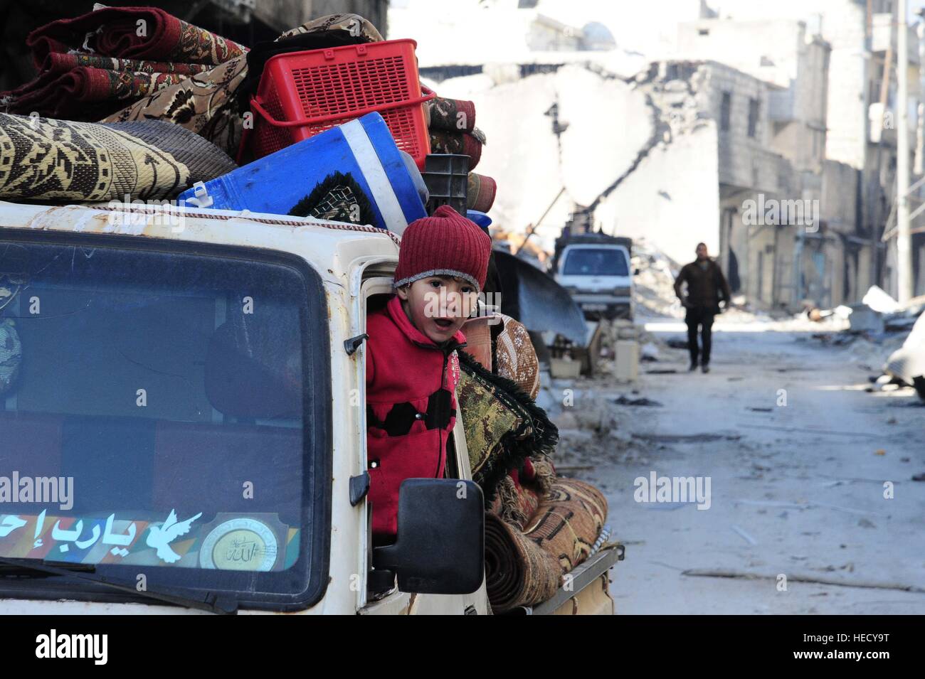 Aleppo, Syrien. 20. Dezember 2016. Eine syrische Mädchen schaut aus ihres Vaters Fahrzeug trägt Sachen, die sie aus ihrer Heimat in ihre zerstörten Stadtteil östliche Aleppo, Nordsyrien, am 20. Dezember 2016 aufgenommen haben. Zivilisten begann wieder in ihren ursprünglichen Nachbarschaften auf ihr Zuhause und ihre Habseligkeiten, die sie zurückgelassen hatte, als sie, östlichen Aleppo vor fast vier Jahren flohen zu überprüfen. Die syrische Armee hat vor kurzem die Rebellen aus diesem Teil der Stadt vor kurzem verdrängt. Bildnachweis: Xinhua/Alamy Live-Nachrichten Stockfoto