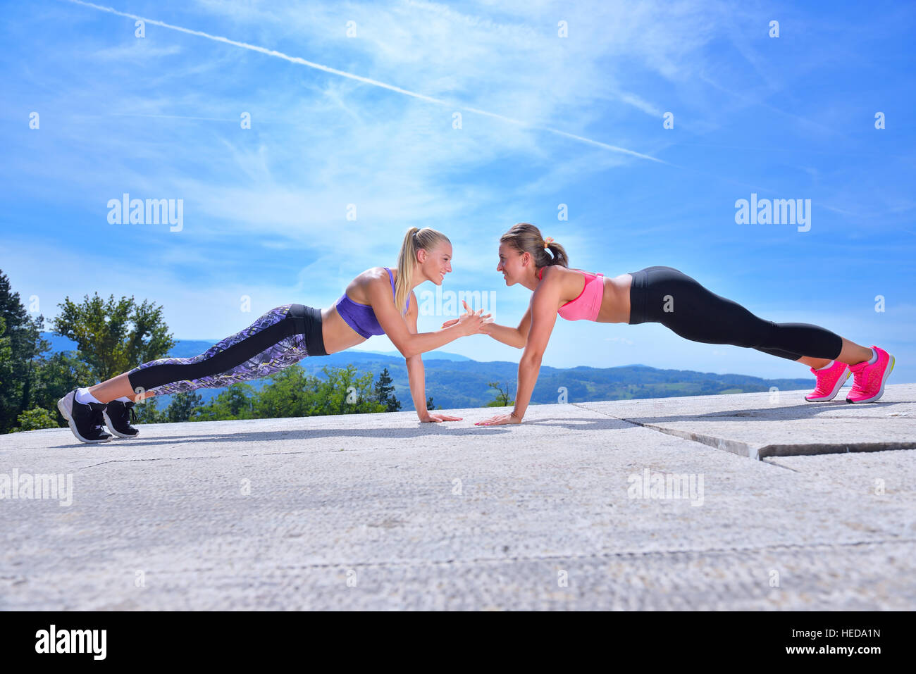 Zwei hübsche Frauen, die Dehnung in einem Park vor Beginn einer Trainingseinheit Stockfoto