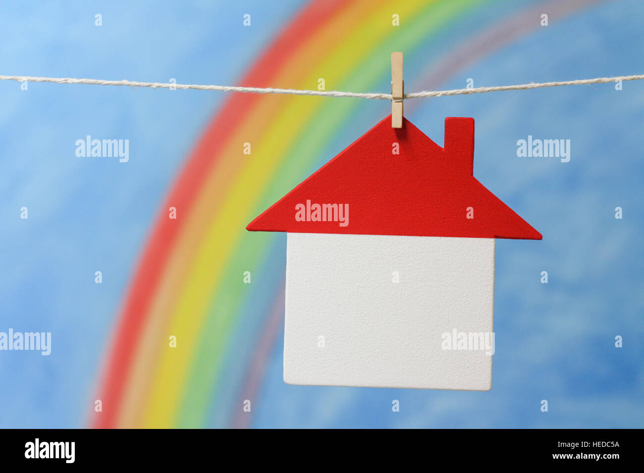 Modell eines Hauses mit einem Regenbogen und blauer Himmel, erläutern Sie das Konzept des Hauses, Darlehen, Hypotheken, Eigenschaft und Kreditvergabe. Stockfoto