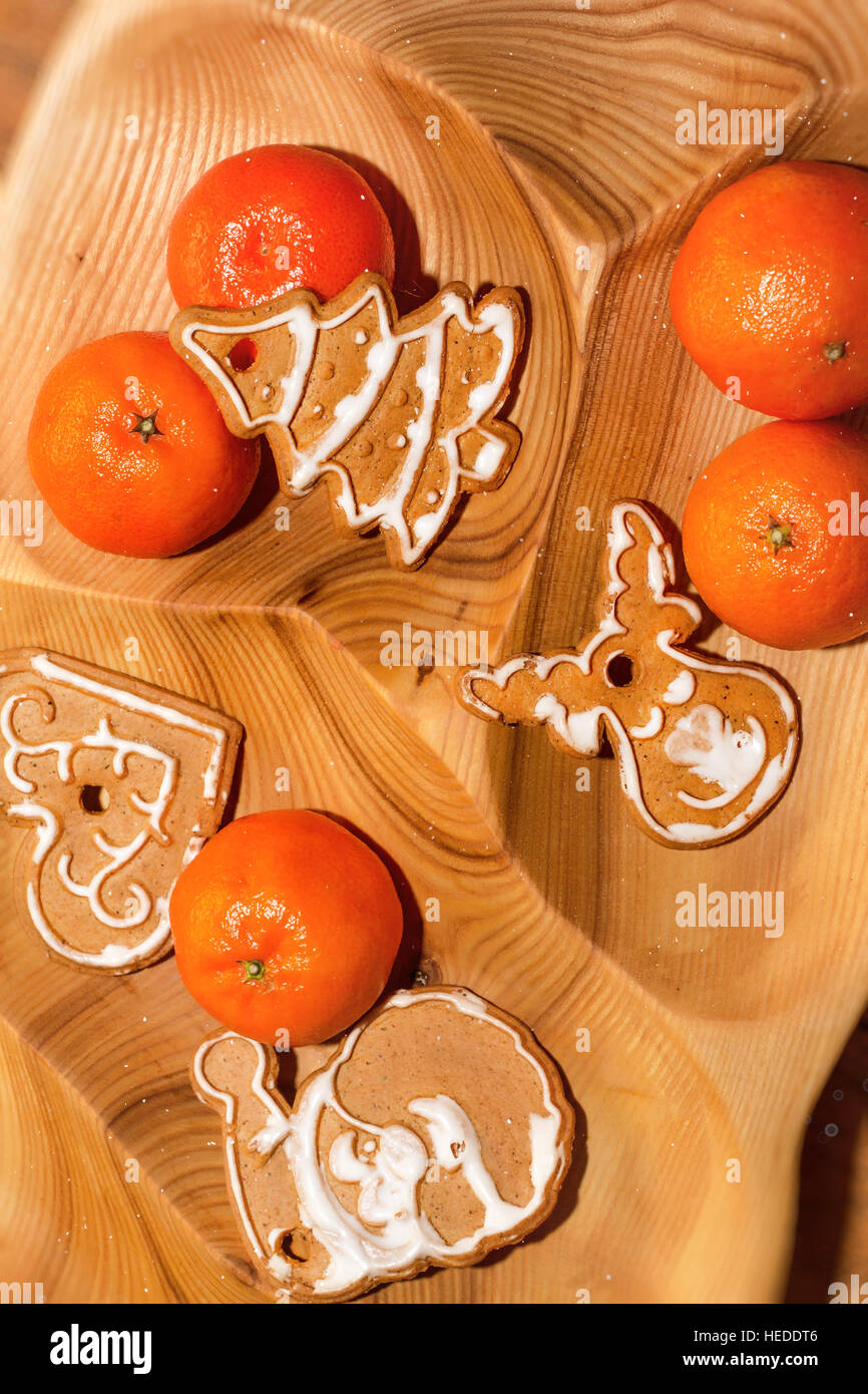 Weihnachtsplätzchen und Mandarinen auf Tablett aus Holz. Neujahr Leckereien für Urlaub, Lebkuchen und Zitrusfrüchte auf Holztextur liegen Stockfoto