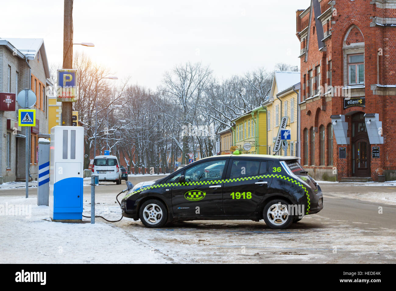 Pärnu, Estland - 10. Januar 2016: Elektro-Taxi Marke Nissan angeheizt elektrische Energie aus Öko-Hightech-Batterie Ladestation. Moderne Technologie Stockfoto