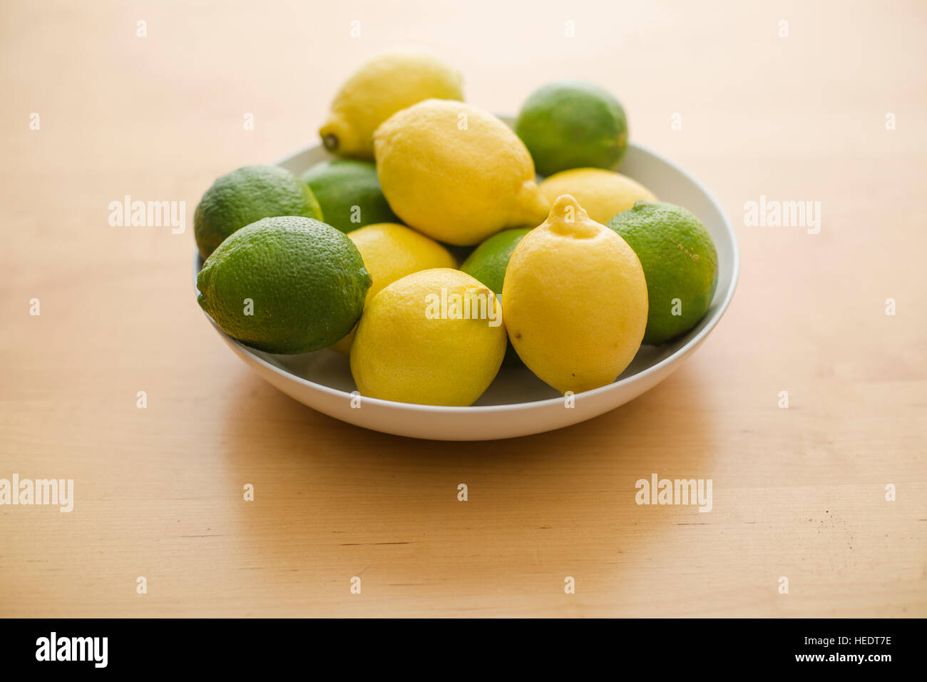 Eine Reihe von einem Zitronen und Limetten in einer weißen Schale gestapelt. Stockfoto
