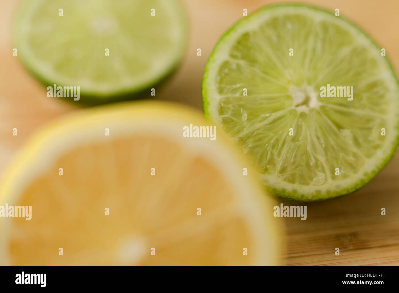 Hälften einer Zitrone und Limetten auf ein Schneidebrett geschnitten. Stockfoto