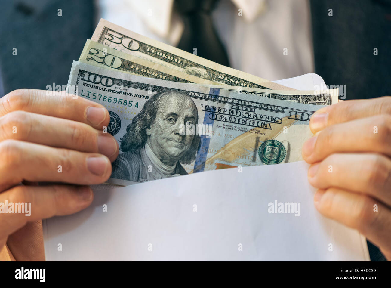 Bestechung und Korruption Konzept in Wirtschaft und Politik mit kaukasischen Geschäftsmann und Cash Geld im weißen Umschlag Stockfoto
