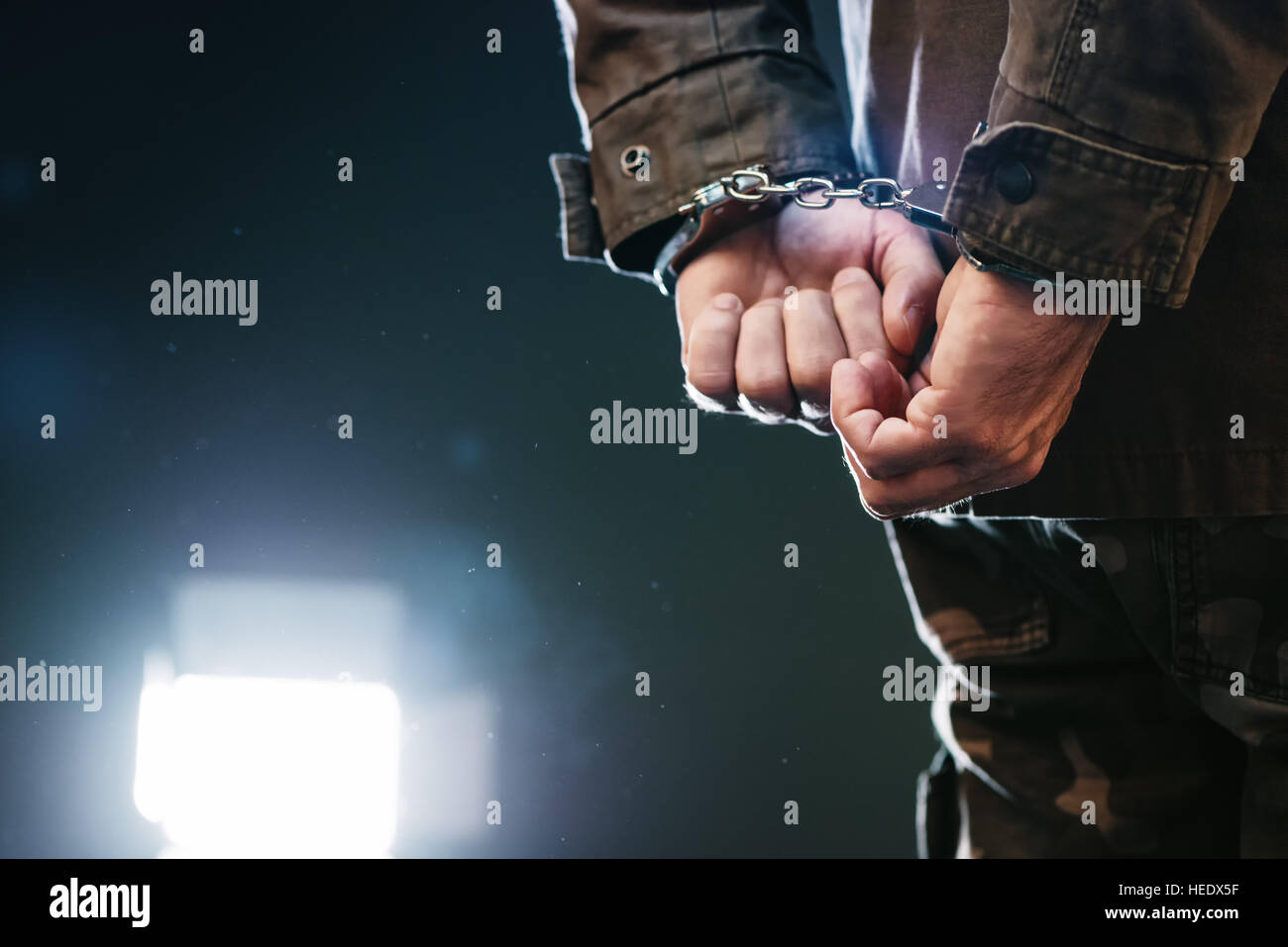 Handschellen Soldaten verhaftet männlichen Offizier in dunklen Gefängniszelle Stockfoto