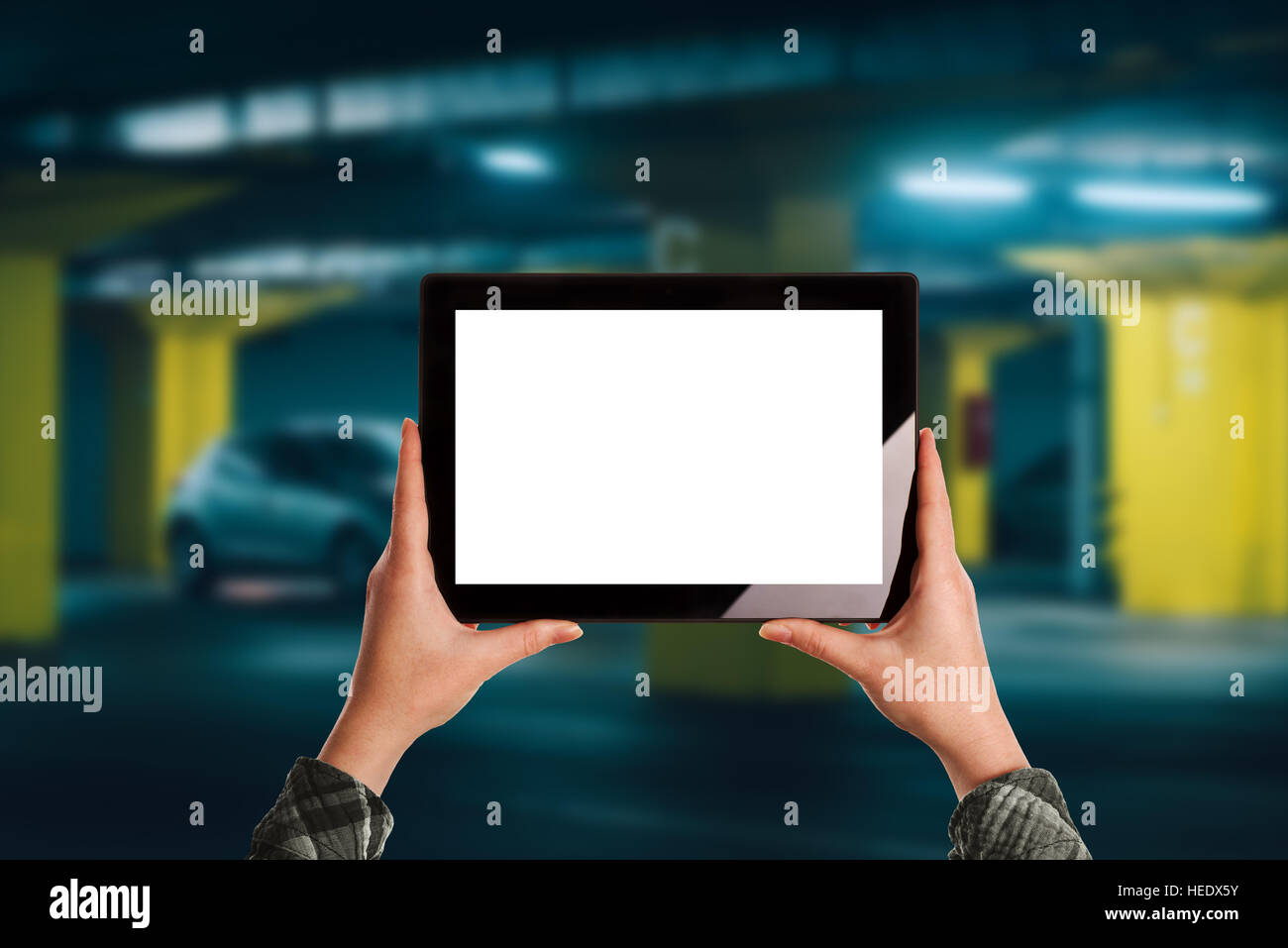 Frau, mit mobilen Anwendung für Parkplätze in Tiefgarage, leere digitale Tablet-Bildschirm als textfreiraum für Mock-up design Stockfoto