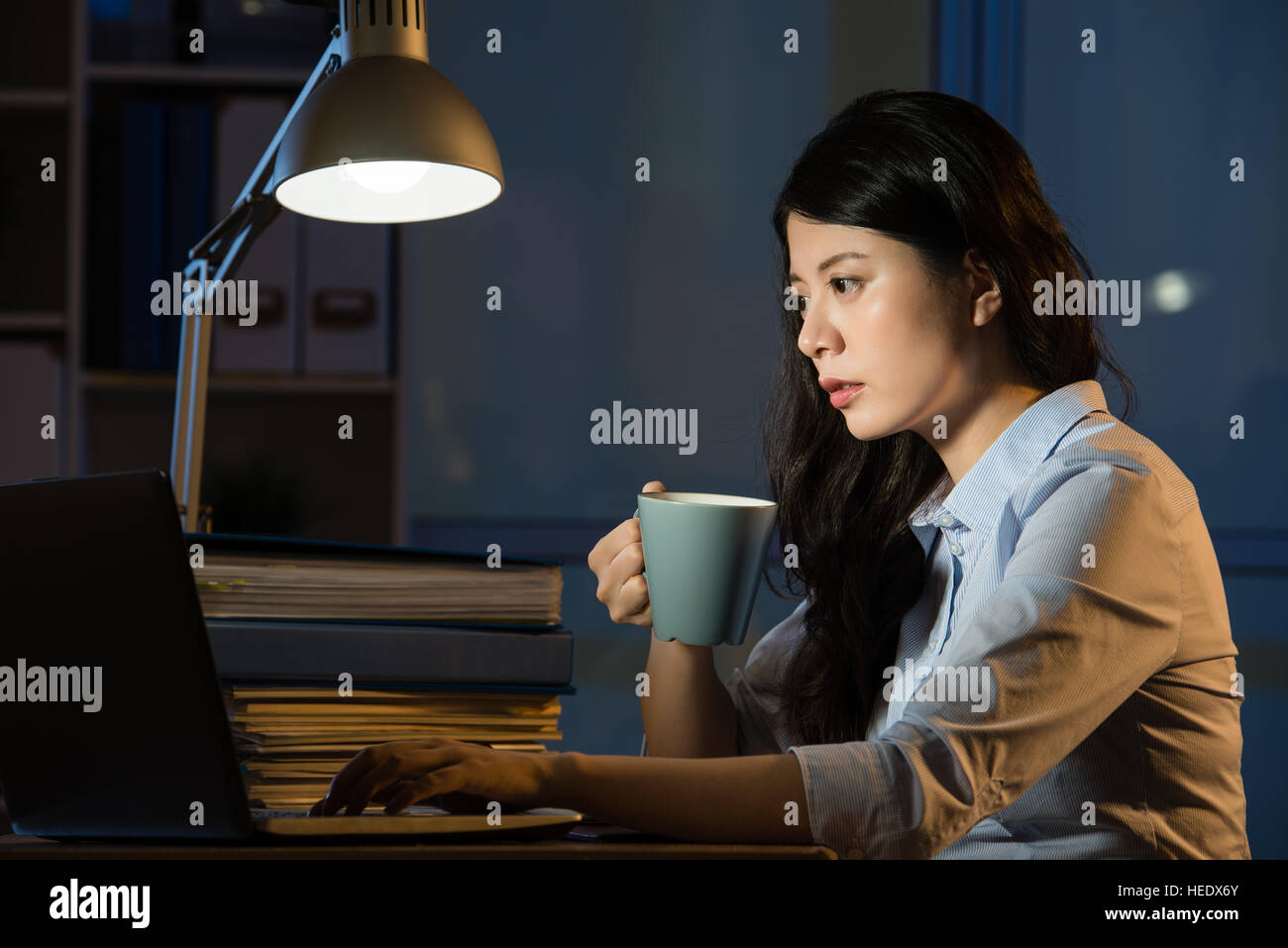 Asien-Geschäft Frau Kaffee trinken erfrischende Überstunden spät in die Nacht. im Innenbereich Office-Hintergrund Stockfoto