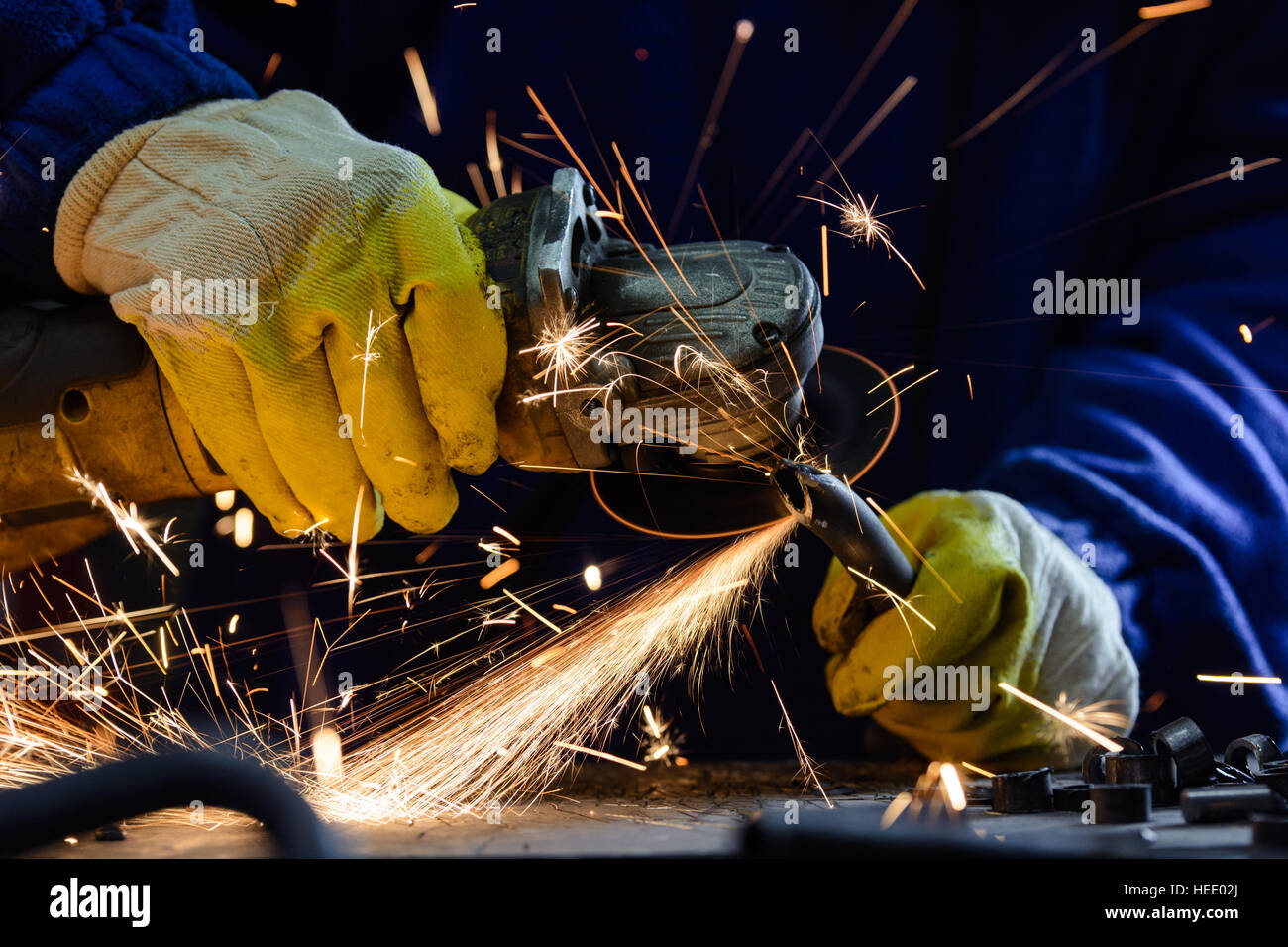 Stahlrohr mit einem Winkelschleifer heißen Funken produzieren schneiden Mann Stockfoto