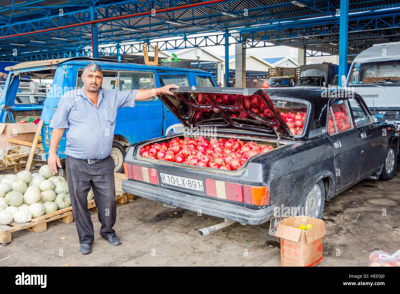 BAKU, Aserbaidschan - 24 SEPTEMBER: Mann verkaufen Reife Granatäpfel aus seinem alten Lada Auto auf lokale Großmarkt in Baku, Aserbaidschan Stockfoto
