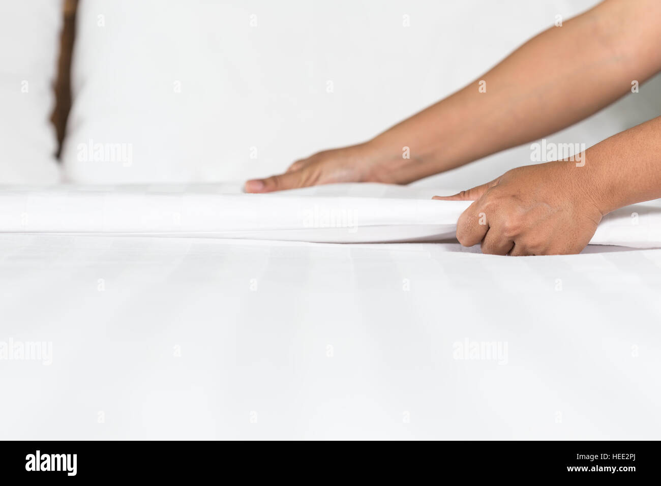 Nahaufnahme der Hand weißen Bettlaken in Hotelzimmer einrichten Stockfoto