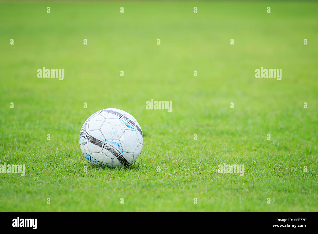 Alte weiße Fußball auf dem Feld und Unschärfe des Spielers im Stadion Stockfoto