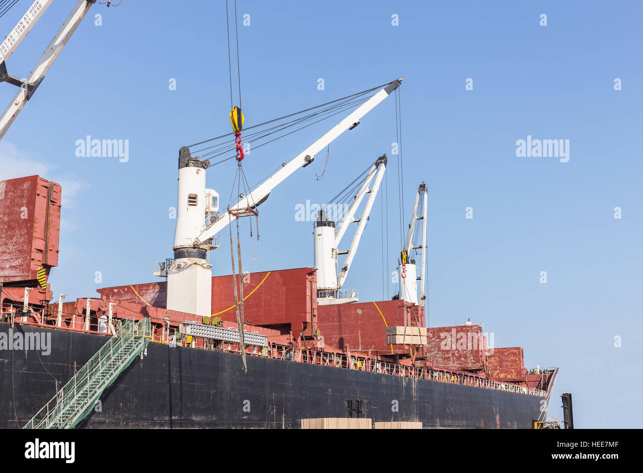 Handelsschiff mit Kranen während der Entladung Container auf das Schiff auf große kommerzielle Schiff im Hafen Stockfoto
