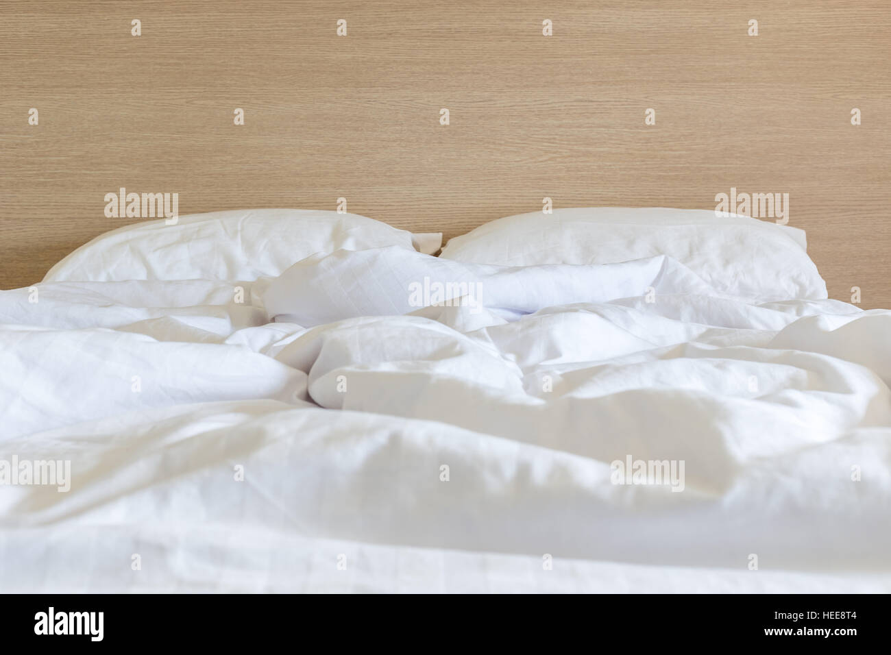 Weiße Bettwäsche, Bettwäsche und Kissen, chaotisch Bettenkonzept hautnah Stockfoto