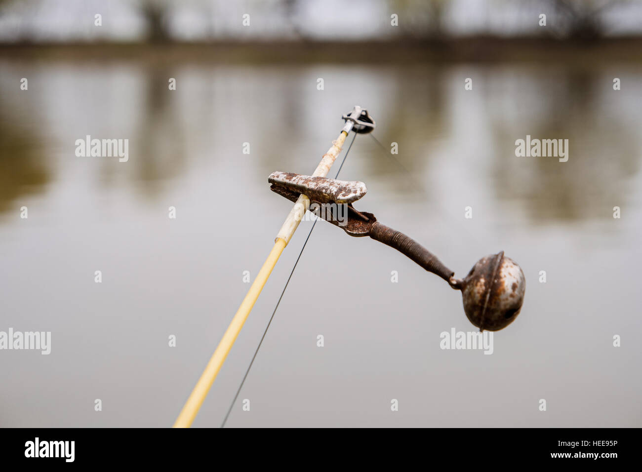 Die Glocke an der Oberseite Angelrute vor Wasseroberfläche. Alte Spinnerei-Geräte. Tiefenschärfe, flachen DOF. Stockfoto