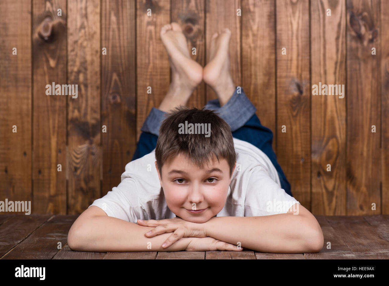 Teenager auf dem Bauch liegend. Vor dem Hintergrund der hölzernen Planken Stockfoto