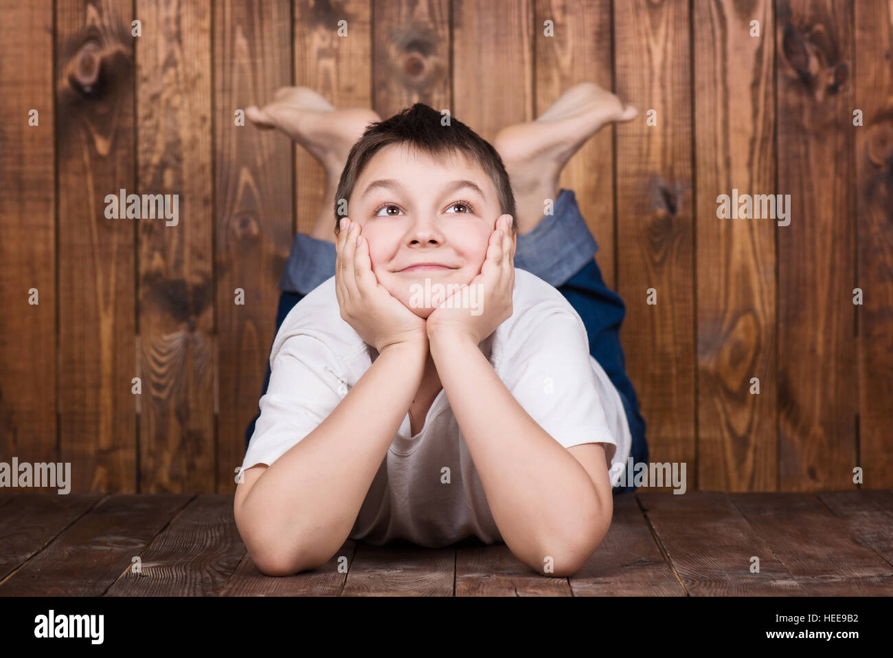 Teenager auf dem Bauch liegend. Vor dem Hintergrund der hölzernen Planken Stockfoto