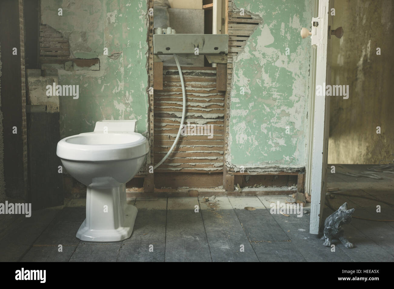 Eine neue Toilette ausgestattet, in einem alten verlassenen Raum umgebaut zu einem Badezimmer Stockfoto