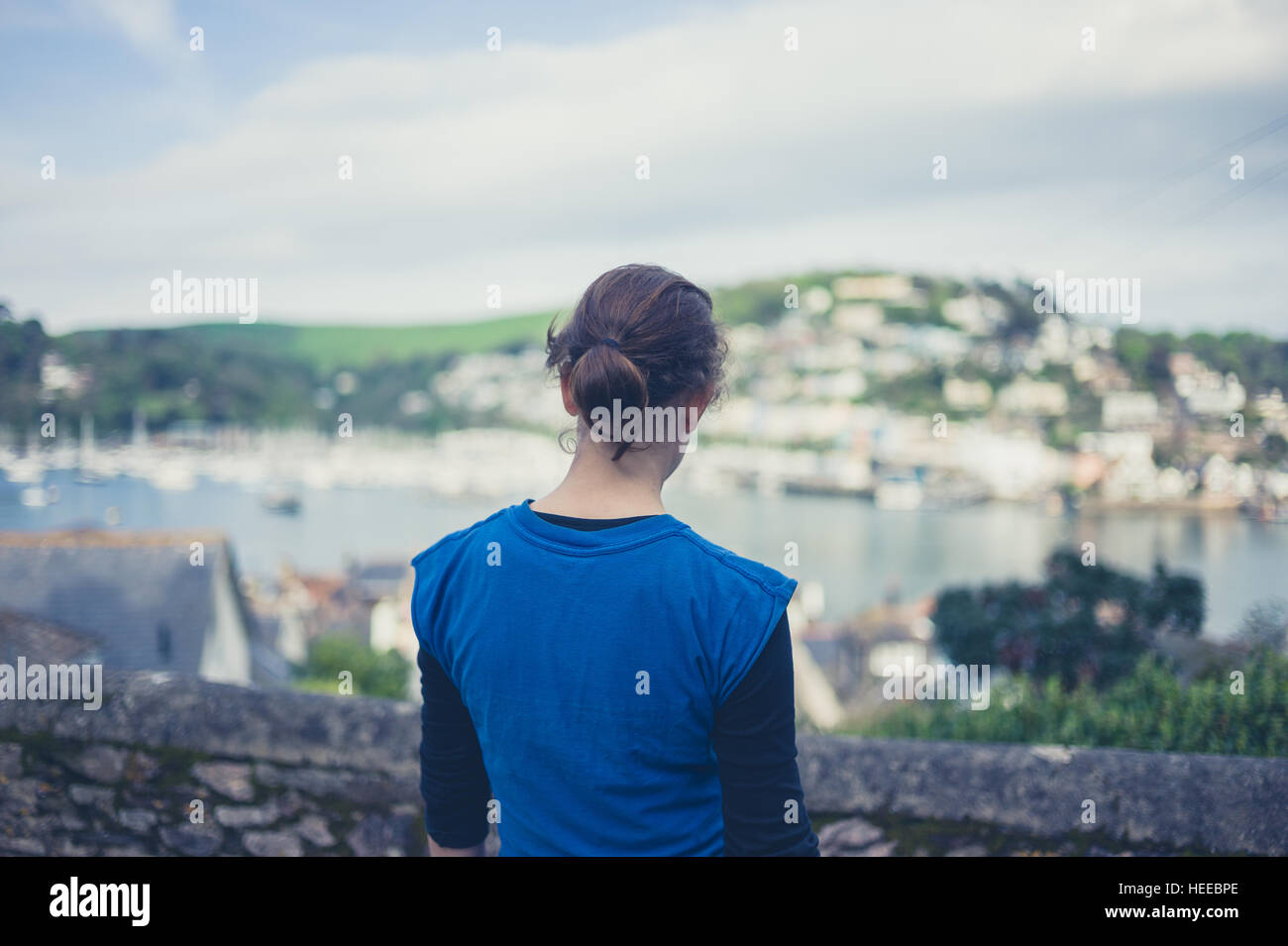 Eine junge Frau ist den Blick auf eine Stadt am Meer bewundern. Stockfoto